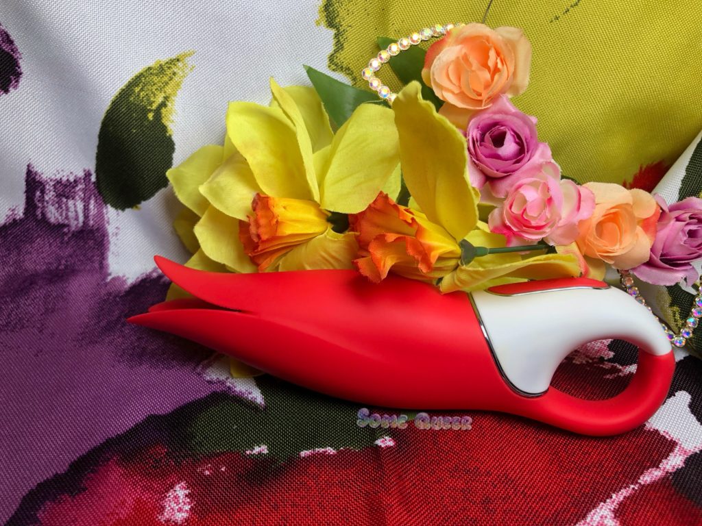 Power Flower by Satisfyer propped in front of a fake bouquet of flowers.